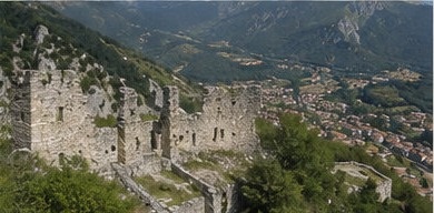 Un pan des remparts d'enceinte de Castel Manfrino, encore debout au milieu de la végétation.