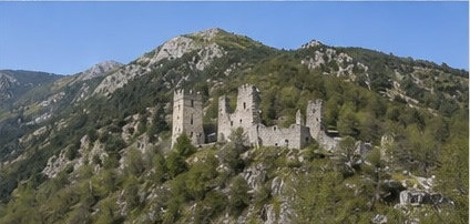 Vue d'ensemble des ruines de Castel Manfrino perchées sur leur crête, montagnes environnantes.
