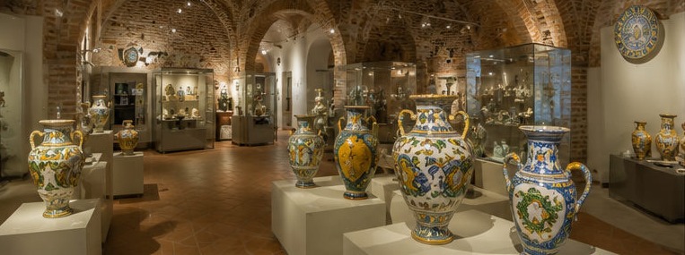 Illustration de la salle voûtée du Museo della Ceramica de Castelli, vitrines et grandes poteries peintes à la main.