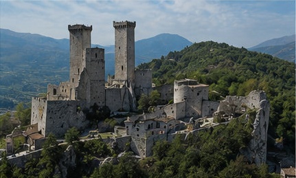 Vue aérienne du Castello Caldora di Pacentro, ses trois tours dominant le village, montagnes de la Majella en arrière-plan.