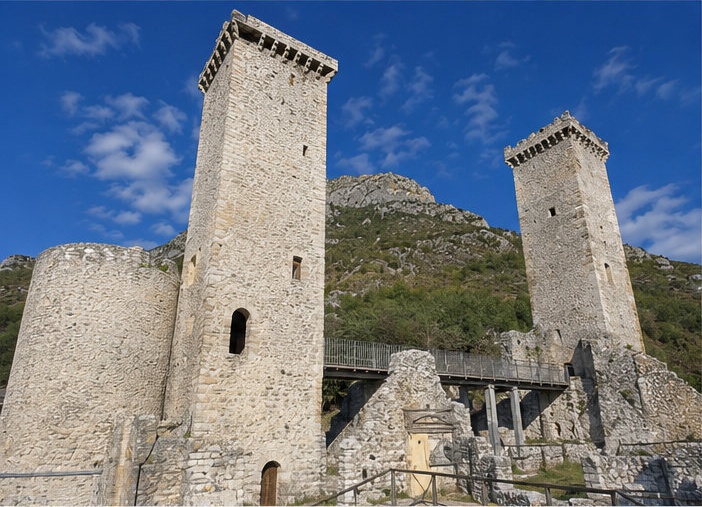 Les deux tours carrées crénelées du Castello Caldora di Pacentro, sur fond de montagnes de la Majella.