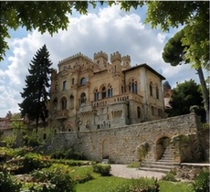 Le Castello della Monica vu depuis le jardin, mur d'enceinte en pierre et escaliers extérieurs.