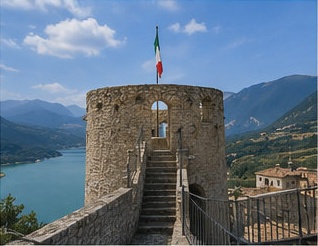 La tour circulaire du Castello di Barrea, drapeau italien au sommet, face au lac de Barrea.