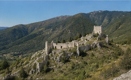 Les ruines du Castello di Bominaco perchées sur leur éperon, au milieu des collines boisées de la vallée de l'Aterno.