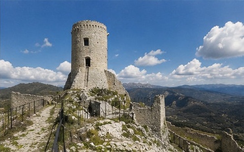 Le donjon circulaire ruiné du Castello di Bominaco, sur son éperon rocheux, panorama sur les montagnes environnantes.