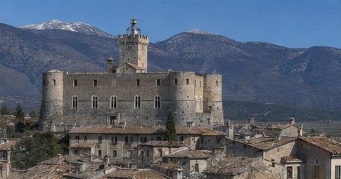 Le Castello Piccolomini di Capestrano dominant le village et la vallée du Tirino, montagnes enneigées en arrière-plan.