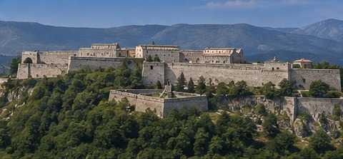 Vue d'ensemble de la forteresse de Civitella del Tronto, entourée de collines boisées.
