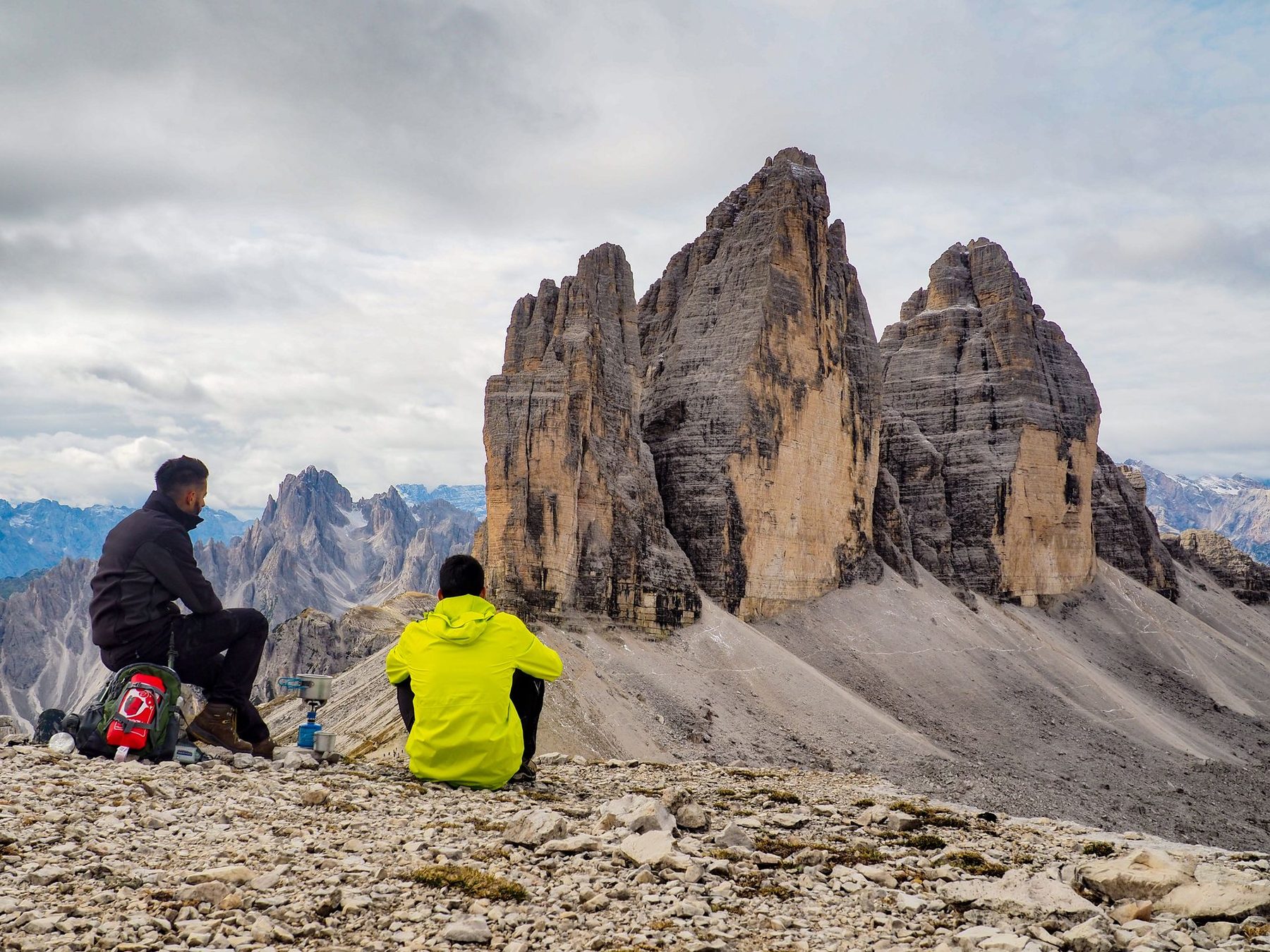 Deux randonneurs assis face aux Tre Cime di Lavaredo, dans les Dolomites.