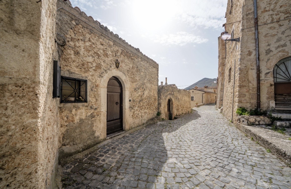 Ruelle pavée de Pacentro menant à un passage voûté en pierre.