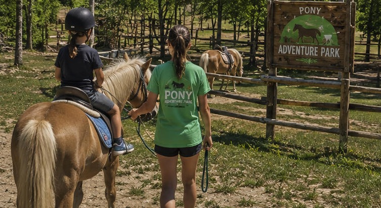 Illustration d'un enfant à cheval sur un poney mené par une accompagnatrice, au Pony Adventure Park.