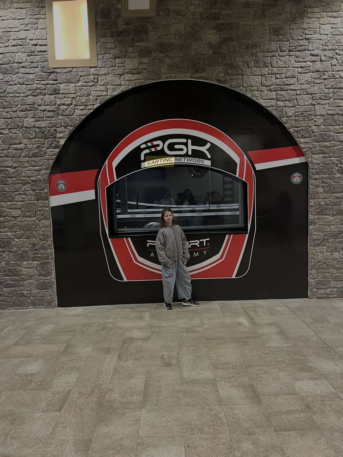 Une enfant devant la façade d'entrée du circuit E-Motion Karting Pescara (PGK Karting Network), dans le centre commercial Borgo d'Abruzzo.