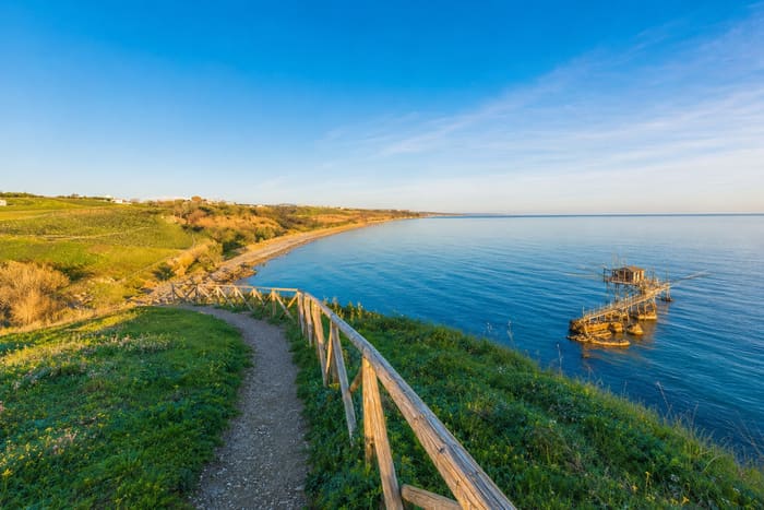 Le sentier panoramique en corniche de la Riserva di Punta Aderci, longeant la côte jusqu'à un trabocco sur pilotis au lever du soleil.