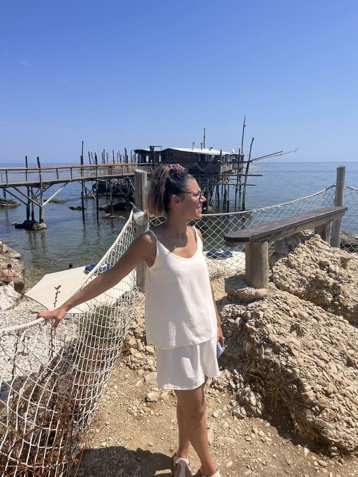 Une visiteuse devant le Trabocco Punta Cavalluccio, sa longue passerelle et sa cabane de restaurant sur pilotis.